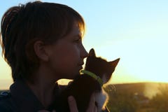 Tir cultivé d'une petite fille et d'un chaton mignons au coucher du soleil photos libres de droits Tir cultivé d'une petite fille et d'un chaton mignons au coucher du soleil photos libres de droits