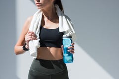 tir cultivé de sportive avec la serviette tenant la bouteille de l'eau image libre de droits tir cultivé de sportive avec la serviette tenant la bouteille de l'eau image libre de droits