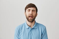 Tir de taille- de type caucasien beau de renversement dans la chemise, pleurnichant ou pleurant comme si il est bébé, se tenant a photographie stock libre de droits Tir de taille- de type caucasien beau de renversement dans la chemise, pleurnichant ou pleurant comme si il est bébé, se tenant a photographie stock libre de droits