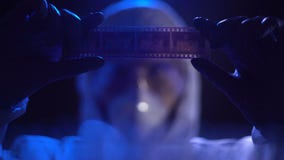 Tira de película de observación del ayudante de laboratorio, buscando pruebas contra criminal metrajes Tira de película de observación del ayudante de laboratorio, buscando pruebas contra criminal metrajes