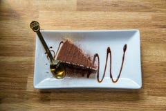 Tiramisu en la placa blanca Torta deliciosa del Tiramisu con los granos de caf? y la menta fresca en una placa en un fondo ligero fotografía de archivo Tiramisu en la placa blanca Torta deliciosa del Tiramisu con los granos de caf? y la menta fresca en una placa en un fondo ligero fotografía de archivo