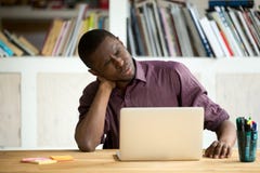 Tired African American office worker suffering from neck pain