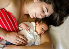 Tired woman holding new born infant