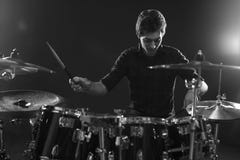 Tiro blanco y negro del batería Playing Drum Kit In Studio foto de archivo Tiro blanco y negro del batería Playing Drum Kit In Studio foto de archivo