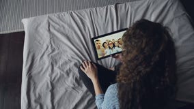 Tiro de alto ángulo de la tableta y de hablar de la tenencia de la mujer con la llamada video de fabricación en línea de los amig metrajes Tiro de alto ángulo de la tableta y de hablar de la tenencia de la mujer con la llamada video de fabricación en línea de los amig metrajes