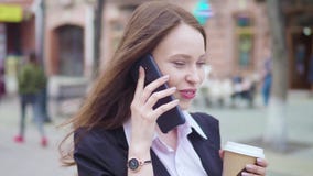 Tiro del carro del smartphone que habla atractivo de la mujer de negocios de la raza mixta y de los paseos de consumición del caf almacen de video Tiro del carro del smartphone que habla atractivo de la mujer de negocios de la raza mixta y de los paseos de consumición del caf almacen de video