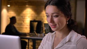 Tiro del primo piano di giovane donna di affari caucasica occupata che scrive sul computer portatile che è concentrato ed efficie fotografia stock Tiro del primo piano di giovane donna di affari caucasica occupata che scrive sul computer portatile che è concentrato ed efficie fotografia stock