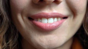 Tiro del primo piano di giovane fronte femminile caucasico grazioso con le labbra tenere che sorridono felicemente diritto davant fotografia stock Tiro del primo piano di giovane fronte femminile caucasico grazioso con le labbra tenere che sorridono felicemente diritto davant fotografia stock