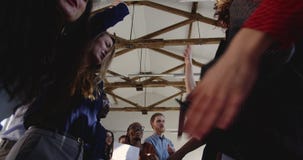 Tiro do baixo ângulo, executivos felizes da equipe que faz a dança do divertimento junto no partido multi-étnico moderno da celeb filme Tiro do baixo ângulo, executivos felizes da equipe que faz a dança do divertimento junto no partido multi-étnico moderno da celeb filme