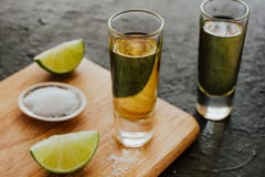 Tiro do Tequila, bebidas fortes alcoólicas mexicanas e partes de cal com sal em México fotografia de stock royalty free Tiro do Tequila, bebidas fortes alcoólicas mexicanas e partes de cal com sal em México fotografia de stock royalty free