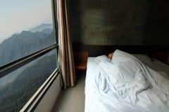 Tiro granangular del hombre joven hermoso que duerme comfortablemente en la cama con la opinión hermosa de la mañana de la natura imagen de archivo libre de regalías Tiro granangular del hombre joven hermoso que duerme comfortablemente en la cama con la opinión hermosa de la mañana de la natura imagen de archivo libre de regalías