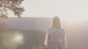 Tiro retroiluminado cinemático de la mujer feliz joven en el vestido blanco que disfruta de la opinión asombrosa del panorama de almacen de video Tiro retroiluminado cinemático de la mujer feliz joven en el vestido blanco que disfruta de la opinión asombrosa del panorama de almacen de video