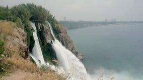 Tiroteo de Timelapse de una cascada tempestuosa, pequeñas ondas en el mar y una vista de la ciudad en la distancia metrajes Tiroteo de Timelapse de una cascada tempestuosa, pequeñas ondas en el mar y una vista de la ciudad en la distancia metrajes