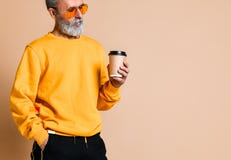 Tiré d'un aîné joyeux tenant une tasse de café blanc et regardant la caméra images stock Tiré d'un aîné joyeux tenant une tasse de café blanc et regardant la caméra images stock
