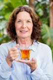 Tisane potable de femme mûre de Smilng image stock Tisane potable de femme mûre de Smilng image stock