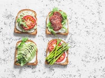 Toast sandwiches with avocado, salami, asparagus, tomatoes and soft cheese on light background, top view. Tasty breakfast, snack o stock photos Toast sandwiches with avocado, salami, asparagus, tomatoes and soft cheese on light background, top view. Tasty breakfast, snack o stock photos