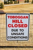 Toboggan hill closed sign posted in a public park once all the snow has melted stock photography Toboggan hill closed sign posted in a public park once all the snow has melted stock photography