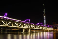 Tobu Railway bridge over Sumida River lit up in purple below illuminated Tokyo Skytree at night stock image Tobu Railway bridge over Sumida River lit up in purple below illuminated Tokyo Skytree at night stock image