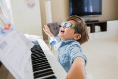 Toddler boy is playing piano at home royalty free stock photo Toddler boy is playing piano at home royalty free stock photo