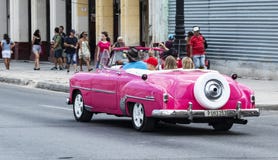 Toerist in uitstekende roze Chevy convertibel in Havana Cuba wordt gedreven die royalty-vrije stock fotografie Toerist in uitstekende roze Chevy convertibel in Havana Cuba wordt gedreven die royalty-vrije stock fotografie