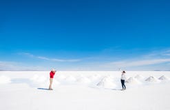 Toeristen die foto's nemen bij saultbanken in Salar de Uyuni stock fotografie Toeristen die foto's nemen bij saultbanken in Salar de Uyuni stock fotografie
