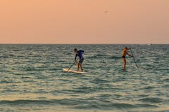 Toeristen die op het overzees bij zonsondergang kayaking stock afbeeldingen Toeristen die op het overzees bij zonsondergang kayaking stock afbeeldingen
