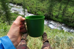 Toeristenhand die plastic mok houden Het kamperen beeld Het genieten van rust en berg van rivier en het bosnomadeleven stock foto's Toeristenhand die plastic mok houden Het kamperen beeld Het genieten van rust en berg van rivier en het bosnomadeleven stock foto's