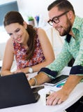 Toevallige stafmedewerkers die op een vergadering met laptop samenwerken royalty-vrije stock foto Toevallige stafmedewerkers die op een vergadering met laptop samenwerken royalty-vrije stock foto