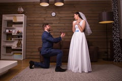 Toilettez la position sur ses genoux contre la jeune mariée heureuse photos stock Toilettez la position sur ses genoux contre la jeune mariée heureuse photos stock