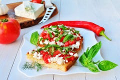 Tomatbruschettas med getost och basilika på plattan Arkivfoton Tomatbruschettas med getost och basilika på plattan Arkivfoton