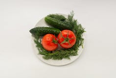 Tomate, concombre, persil d'un plat blanc images stock Tomate, concombre, persil d'un plat blanc images stock
