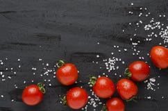 Tomates y sal frescos deliciosos en la tabla negra foto de archivo libre de regalías Tomates y sal frescos deliciosos en la tabla negra foto de archivo libre de regalías