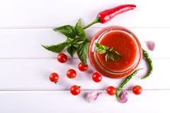 Tomato ketchup sauce with cherry tomatoes and red hot chili peppers, garlic and herbs in a glass jar on white background. royalty free stock photo Tomato ketchup sauce with cherry tomatoes and red hot chili peppers, garlic and herbs in a glass jar on white background. royalty free stock photo