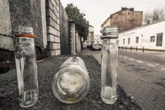 3 tomma övergav lilla alkoholflaskor på den tomma gatan i W royaltyfri foto 3 tomma övergav lilla alkoholflaskor på den tomma gatan i W royaltyfri foto