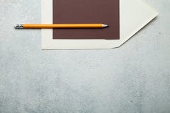 Tomt papper för textbrunt, beige kuvert och blyertspennamummel mot vit bakgrund royaltyfri fotografi Tomt papper för textbrunt, beige kuvert och blyertspennamummel mot vit bakgrund royaltyfri fotografi