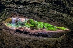 Toneeldie de zomerlandschap van Chinarev-waterval in kloof van binnenuit rotsachtig hol in de bergen van de Kaukasus door Mezmai royalty-vrije stock afbeeldingen Toneeldie de zomerlandschap van Chinarev-waterval in kloof van binnenuit rotsachtig hol in de bergen van de Kaukasus door Mezmai royalty-vrije stock afbeeldingen