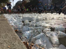Toneladas de povos plásticos vazios dos copos que correm sobre em Berlin Marathon fotografia de stock Toneladas de povos plásticos vazios dos copos que correm sobre em Berlin Marathon fotografia de stock
