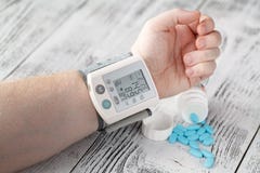 Tonometer wysokiego ciśnienia krwi przejaw na male& x27; s ręka nadciśnienie medyczne pigułki na tle fotografia royalty free Tonometer wysokiego ciśnienia krwi przejaw na male& x27; s ręka nadciśnienie medyczne pigułki na tle fotografia royalty free