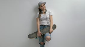 Tonårs- flicka med en skateboard som gör ett hastighetstecken stock video Tonårs- flicka med en skateboard som gör ett hastighetstecken stock video