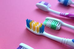 Multi-colored toothbrushes lie on a pink background stock images Multi-colored toothbrushes lie on a pink background stock images