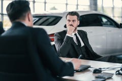 Top sales manager and customer at dealership showroom stock photo Top sales manager and customer at dealership showroom stock photo
