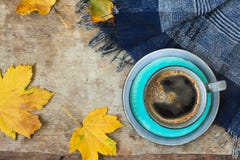 Top view of a blue cup of coffee, blue scarf and golden leaves on wooden background royalty free stock images Top view of a blue cup of coffee, blue scarf and golden leaves on wooden background royalty free stock images