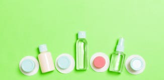 Top View Composition Of Small Travelling Bottles And Jars For Cosmetic Products On Green Background. Facial Skin Care Concept With Royalty Free Stock Photos Top View Composition Of Small Travelling Bottles And Jars For Cosmetic Products On Green Background. Facial Skin Care Concept With Royalty Free Stock Photos