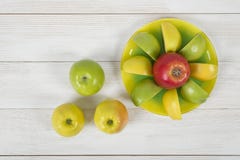 Top view of juicy yellow and green apples placed around the whole apple on a saucer. royalty free stock images Top view of juicy yellow and green apples placed around the whole apple on a saucer. royalty free stock images