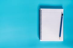 Top view notebook paper on blue pastel color background with spa stock image Top view notebook paper on blue pastel color background with spa stock image