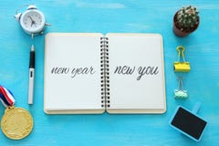 Top view of notebook and text NEW YEAR NEW YOU, cup of coffee over wooden desk. stock photo Top view of notebook and text NEW YEAR NEW YOU, cup of coffee over wooden desk. stock photo
