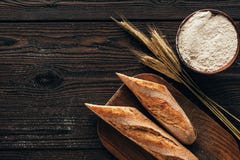 Top View Of Arranged Pieces Of French Baguette On Cutting Board, Wheat And Flour In Bowl Royalty Free Stock Photography Top View Of Arranged Pieces Of French Baguette On Cutting Board, Wheat And Flour In Bowl Royalty Free Stock Photography