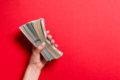 Top View Of Female Hand Holding A Thick Pack Of Different Dollar Bills On Colorful Background. Wage And Salary Concept With Empty Royalty Free Stock Photo Top View Of Female Hand Holding A Thick Pack Of Different Dollar Bills On Colorful Background. Wage And Salary Concept With Empty Royalty Free Stock Photo