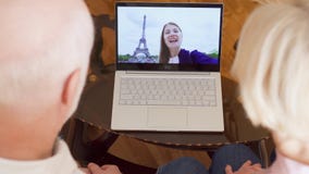 Senior couple at home having video chat with student daughter from Paris, Eiffel Tower on background stock video footage Senior couple at home having video chat with student daughter from Paris, Eiffel Tower on background stock video footage