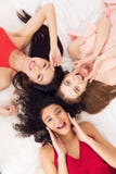 Top view three girls lying on bed. They are celebrating women`s day March 8. stock photos Top view three girls lying on bed. They are celebrating women`s day March 8. stock photos